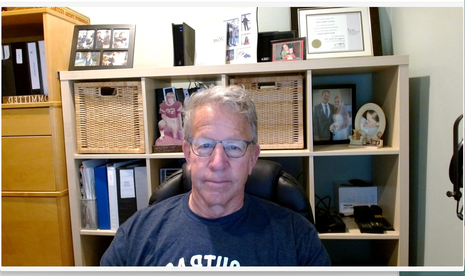 Before: a dim, cluttered home office on camera.